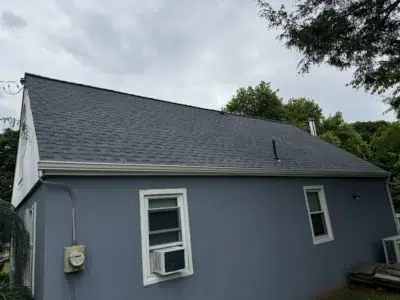 Back view of a residential home in Skippack, PA, with a newly completed shingle roof featuring Biscayne Blue GAF Timberline HDZ shingles.