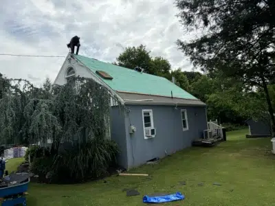 Corner view of a residential home in Skippack, PA, after roofers have torn off all old shingles and are preparing for a full shingle roof replacement.