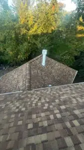 Completed multi-level shingle roof with new roofing around piping system by XL Home Improvements.
