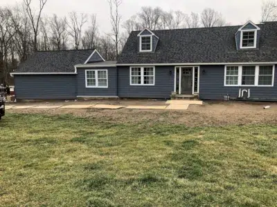 Front of a Berwyn, PA home with new siding and gutters installed by XL Home Improvements, crew cleaning up after completing the job.