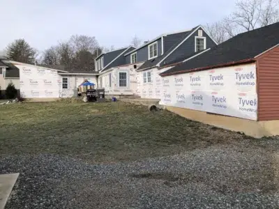 Home in Berwyn, PA with old aluminum siding and gutters removed, now featuring Tyvek House Wrap installation by XL Home Improvements.