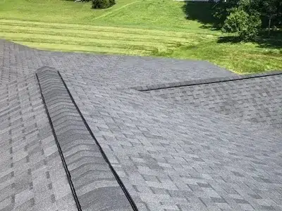 Closeup view of cleanly installed shingles on a brand-new roof in Perkasie, PA, featuring two new ridge vents with shingles flush around them.