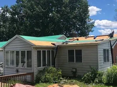 Corner view of the backside of a home in Perkasie, PA, showing ice and water shield being installed after old shingles have been removed.