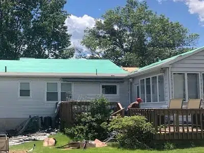 Installation of synthetic underlayment and ice and water shield on a residential roof after old shingles have been removed.