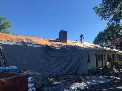 XL Home Improvements crew laying down a protective tarp and inspecting the roof before a shingle roof replacement in Perkasie, PA.