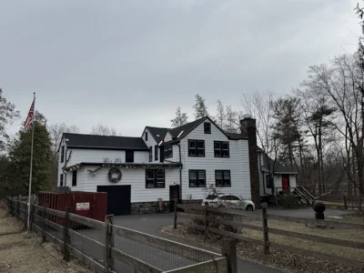 Front view of a Schwenksville home with completed roof replacement, Rustic Black Tamko Heritage shingles, and custom copper valleys.