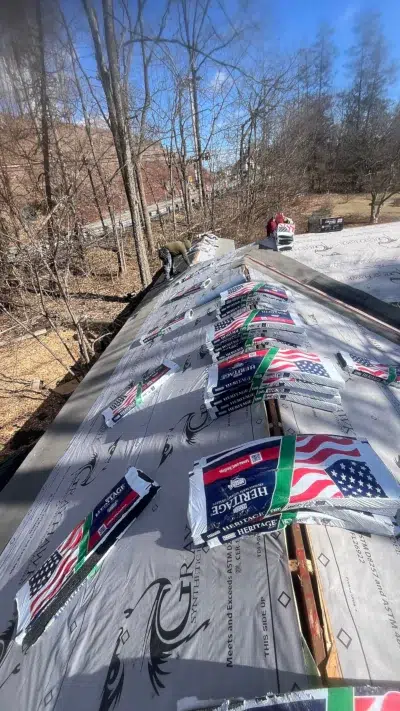 Roofing crew installing synthetic underlayment with Tamko Heritage shingles ready for installation at a Schwenksville home.