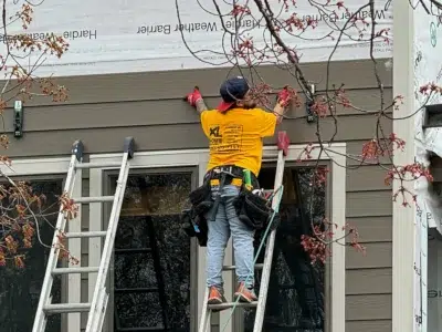 Worker installing new siding during roof and siding replacement in Green Lane PA by XL Home Improvements