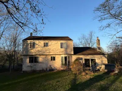 rear view of home in Kulpsville PA before new roof installation with worn shingles