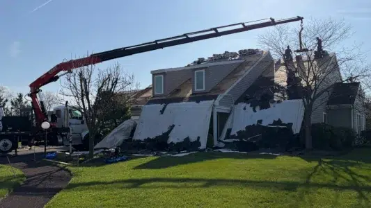 Roof tear-off process in Harleysville PA with shingles being removed and debris cleared