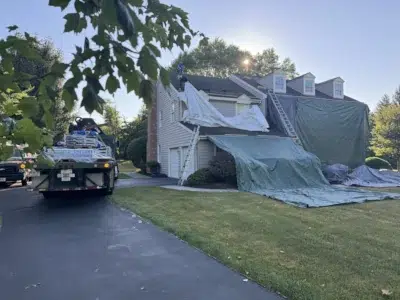 Roof work in progress in Collegeville PA with protective coverings and materials staged during installation